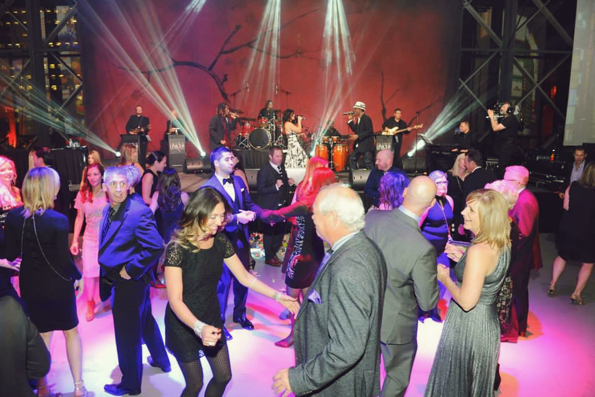 A party band's lead singer reaching out to the crowd from the stage