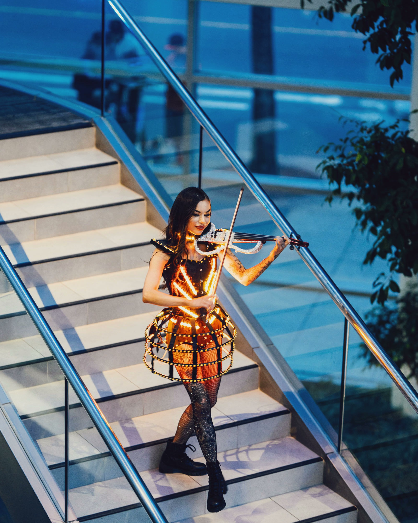 A violinist playing as she walks down an outdoor staircase